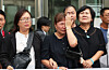 Families of victims who died in a fire that broke out at an Aricell battery plant shed tears as they speak to reporters after a court ruling at the Suwon District Court on Sept. 23 in Gyeonggi. [YONHAP]