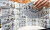 An employee sorts dollar bills at Hana Bank’s counterfeit response center in central Seoul on Nov. 26. [NEWS1]