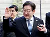 Democratic Party leader Lee Jae-myung waves to supporters as he heads into his second trial at the Seoul High Court in Seocho District, western Seoul, on Feb. 26. [YONHAP]