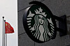 The Chinese flag flies near the Starbucks logo outside a cafe of the coffee chain in Beijing, China, on Aug. 3, 2022. [REUTERS/YONHAP]