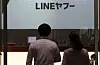 Workers pass by the Line Yahoo's headquarters in Tokyo, Japan, on Thursday. [YONHAP]