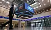 A pedestrian walks by an electronic board displaying closing rates of Korean stock markets at the Korea Exchange headquarters in western Seoul on Dec. 30, 2024. [NEWS1]