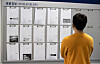 A student reads job notices on a bulletin board on a campus wall at a university in Seoul on April 12, 2021. [NEWS1]