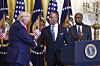 President Donald Trump shakes hands with U.S. Secretary of Housing and Urban Development Eric Turner as Former Housing and Urban Development Secretary Dr. Ben Carson, right, looks on during a reception for Black History Month in the East Room of the White House in Washington on Feb. 18.  [UPI/YONHAP]