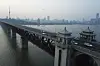 The sun sets behind the Wuhan Yangtze River Bridge and the Tortoise Mountain TV Tower in Wuhan in central China's Hubei province on April 12, 2020. [AP/YONHAP]