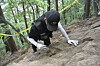 A member from the defense ministry's excavation team brushes off dirt from the remains of Pfc. Kang Nong-won in Inje County, Gangwon, in June 2020. [YONHAP]