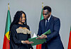Yvon Detchenou, Benin's Minister of Justice and Legislation, right, presents citizenship documents to singer Ciara at a ceremony in Cotonou, Benin on July 26. [AP/YONHAP]