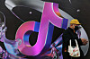 A man stands near a giant sign for Chinese company ByteDance's app TikTok, known locally as Douyin, during China Fashion Week in Beijing on March 31, 2025. [REUTERS/YONHAP]