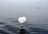 A balloon carrying trash, suspected to have been sent from North Korea, drifts in the sea near Incheon on June 9. [YONHAP]