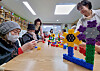 Older adults play with toy bricks at a nursing home that used to be a kindergarten in Gwangju on Jan. 3. The bricks were used by the former kindergarten students. [HWANG HEE-KYU]