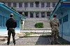 South Korean soldiers stand guard at the Joint Security Area (JSA) in Panmunjom, inside the DMZ, during a tour on July 19, 2022. The JSA, with its iconic blue huts (South Korean side) and the grey Panmun-gak building (North Korean side in the background), is one of the few spots in the DMZ where troops from both Koreas face each other directly under the armistice agreement. [JOONGANG ILBO]