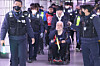Park Kyung-seok, head of the Solidarity Against Disability Discrimination (SADD), is escorted out of City Hall Station in central Seoul on Nov. 30, 2023. [YONHAP]