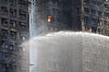 Fire burns inside a window of the damaged towers of the Wang Fuk Court housing estate, where a major fire engulfed bamboo scaffolding across multiple blocks, killing at least 44 people and leaving almost 300 missing, in Hong Kong on Nov. 27. [REUTERS/YONHAP]