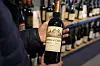 Carlos Olivares holds a bottle of Ch?eau du Cauze, Saint-Emilion Grand Cru, a French Bordeaux wine, before purchasing it at DECANTsf Bottle Shop and Bar in San Francisco, on March 13. [AP/YONHAP]