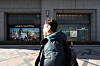 A pedestrian walks by a row of luxury good stores at a department store in Seoul on Jan. 2. [YONHAP]