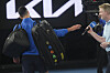 Novak Djokovic hands microphone to Jim Courier after declining to do a customary post-match interview at the Australian Open tennis championship in Melbourne, Australia, Sunday, Jan. 19, 2025. [AP/YONHAP]