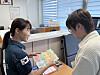 A police officer, left, explains the content of a pamphlet to reporter Chutian Shi as part of Jongno Police Station's recent initiative to prevent crimes. [YOON SEUNG-JIN]