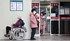 A patient in a wheelchair and a guardian wait in front of an emergency medical center in Seoul on Wednsday morning. Around 71 percent of interns and residents at 100 major hospitals nationwide submitted their resignation letters as of 10 p.m. Tuesday to protest the government's medical school enrollment quota hike. [YONHAP]
