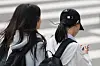 A middle school student uses her phone while leaving school in Seoul on Nov. 4, 2024. [YONHAP]