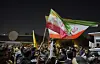 Protesters carry Iranian flags during a protest against Israeli attacks on Iran, at a bridge leading to the fortified Green Zone where the U.S. embassy is located in Baghdad, Iraq on June 17. [AP/YONHAP]
