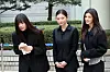 Members of girl group NewJeans (from left) Hyein, Haerin and Danielle answer questions from reporters outside the Seoul Central District Court building in southern Seoul on March 7 after taking part in a lawsuit against their agency, ADOR. [NEWS1]