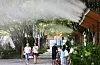 Citizens rest under sprinklers at a park in Seongdong District, eastern Seoul on July 9. [NEWS1]