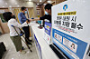 A patient presents her mobile ID card at a hospital in Dongjak District, southern Seoul, to access medical treatment under the national health insurance system. Beginning Monday, patients visiting medical facilities are required to present an ID card to receive health insurance coverage. [NEWS1]