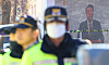 Police stand on guard outside President Yoon Suk Yeol's official residence in Yongsan District, central Seoul, on Dec. 24. A video of the president is broadcast on an outdoor screen mounted by his supporters behind the police officers, who were there to maintain a distance between dueling rallies for and against his impeachment. [YONHAP]