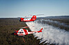 A CH-47 Chinook helicopter, rear, modified by Canada’s Coulson Aviation for firefighting and deployed to battle wildfires in Australia, flies with a Bell 412EP helicopter operated by the Australian government. [COULSON]