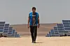 Actor Theo James walks amid solar panels powering the Azraq Refugee Camp in Jordan on July 25, 2023. The solar plant, which was funded by IKEA Foundation, provides the camp with 79 percent of its electricity needs. [UNITED NATIONS HIGH COMMISSIONER FOR REFUGEES]