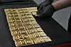 A worker lays out one kilogram gold cast bars with 99.99 percent purity ready for sale at the ABC Refinery in Sydney, Australia, Wednesday, April 30. [AP/YONHAP]