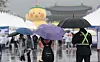 Pedestrians walk by Gwanghwamun Square in central Seoul with umbrellas as rain poured down in Korea on April 19. [YONHAP]