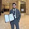 Muhammad Naufal Bin Omar poses for a photo with his promotion certificate after being elevated to head of Glutanex's content department. [MUHAMMAD NAUFAL BIN OMAR]