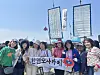 Japanese citizens participating in a ceremony to celebrate the arrival of a replica ship of the past Joseon Tongsinsa diplomatic mission from Korea pose for a photo with a banner welcoming the ship at the Port of Osaka in Japan on May 13. [YONHAP]