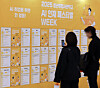 Job seekers read notices for positions at a job festival held at Dongdaemun Design Plaza in Jung District, central Seoul, on Dec. 2. [YONHAP]