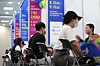 Job-seekers talk to company representatives at a career fair at Yeungnam University in Gyeongsan, North Gyeongsang, on Tuesday. [YONHAP]