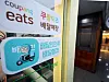 Baedal Minjok and Coupang Eats stickers on a restaurant in Seoul on Monday [NEWS1]