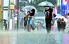 People walk across Myeongdong under umbrellas in heavy rain in central Seoul on Sept. 16. [YONHAP]