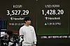 A currency trader passes by a screen showing the Kospi, top left, and the foreign exchange rate between the U.S. dollar and Korean won at the foreign exchange dealing room of the Hana Bank headquarters in Seoul on Oct. 13. [AP/ YONHAP]