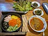 Korean dishes, including Bibimbap, that were cooked by two Ukrainian refugees are seen served in a Korean restaurant, Haru, in Warsaw, Poland. [JOONGANG ILBO]