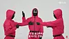 The henchmen, or Pink Guards, from Netflix's 'Squid Game' demonstrate how to play rock, paper, scissors, minus one in a YouTube video. [SCREEN CAPTURE]