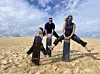 Mila Jin, far right, playfully poses for a photo with her son and husband during their sandboarding tour in Port Stephens in New South Wales, Australia, on Aug. 11, 2024. She made a month-long trip with her son to Sydney in the year. [MILA JIN]