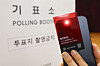 An election official checks for illegal cameras using a detection card distributed by the National Election Commission in Yongsan District, central Seoul, on June 2. [JOINT PRESS CORPS]