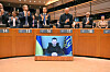 Members of the EU Parliament clap during a standing ovation prior to a video conference speech the Ukraine's President Volodymyr Zelensky (screen) in Brussels on Tuesday, on the 1,000th day of the Russian invasion. [AFP/YONHAP]