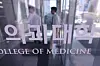 Personnel enter a medical school in Seoul on April 8. [YONHAP]