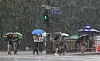 People with umbrellas cross a crosswalk near Gwanghwamun in Jongno District, central Seoul, as a heavy rain advisory was issued for the city on Tuesday. [YONHAP]