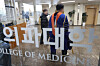 A student wearing a graduate gown is seen inside a medical school building in Seoul on Feb. 24. [YONHAP]