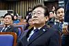 Democratic Party leader Lee Jae-myung watches news coverage of President Yoon Suk Yeol's arrest by the Corruption Investigation Office for High-ranking Officials while attending an emergency general meeting of lawmakers held at the National Assembly in Yeouido, western Seoul, on Jan. 15. [NEWS1]