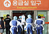 Medical staff carry an urgent patient on a bed at an entrance to an emergency room at Ajou University Hospital in Suwon, Gyeonggi, on Wednesday. [YONHAP]
