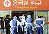 Medical staff carry an urgent patient on a bed at an entrance to an emergency room at Ajou University Hospital in Suwon, Gyeonggi, on Wednesday. [YONHAP]